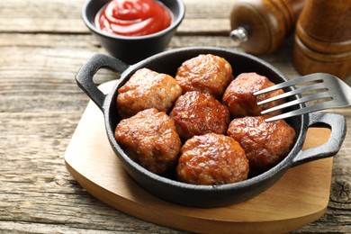 Photo of Tasty meatballs in baking dish served on wooden table, closeup