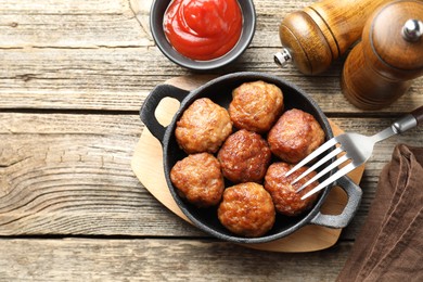 Photo of Tasty meatballs in baking dish served on wooden table, flat lay