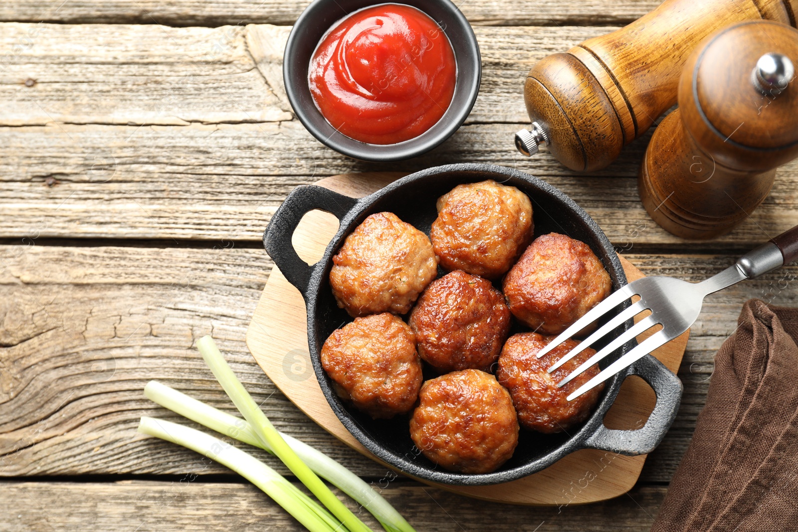 Photo of Tasty meatballs in baking dish served on wooden table, flat lay