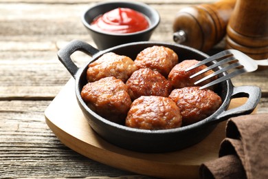 Photo of Tasty meatballs in baking dish served on wooden table, closeup