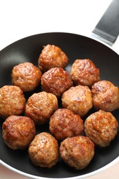 Photo of Tasty meatballs in frying pan on white table, closeup