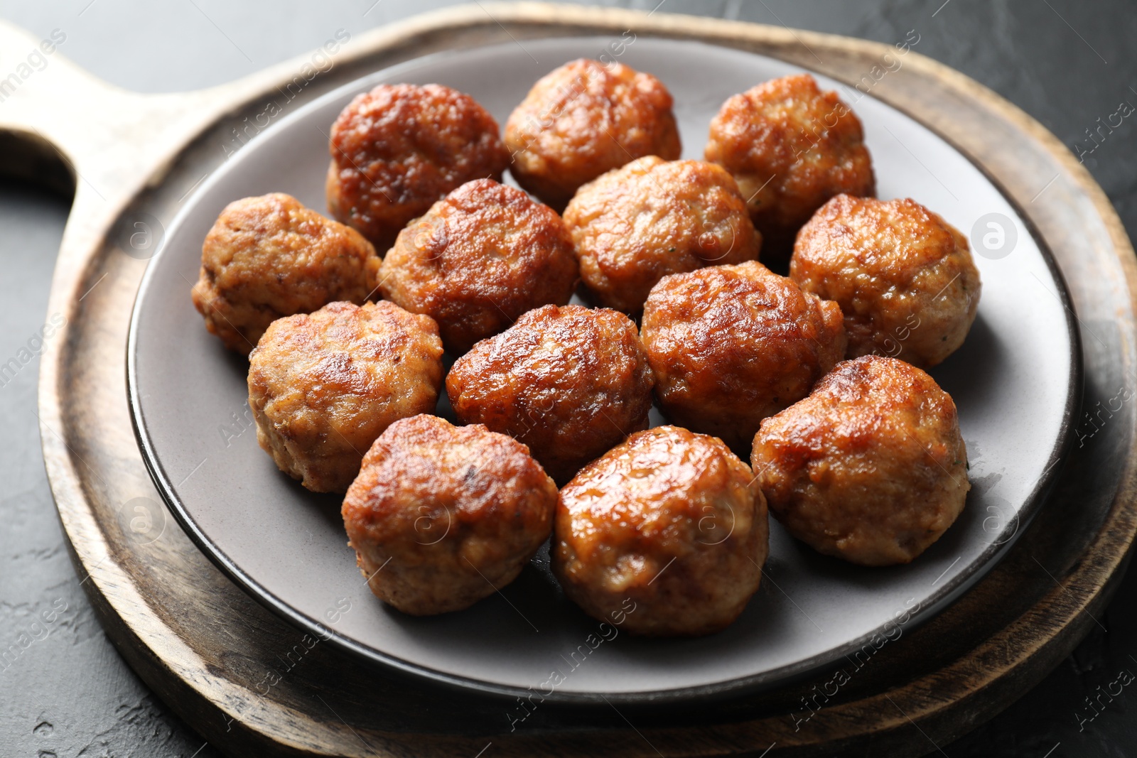 Photo of Tasty cooked meatballs on grey table, closeup