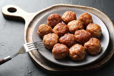 Photo of Tasty cooked meatballs served on grey table, closeup