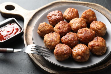 Photo of Tasty cooked meatballs served on grey table