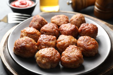 Photo of Tasty cooked meatballs served on grey table, closeup