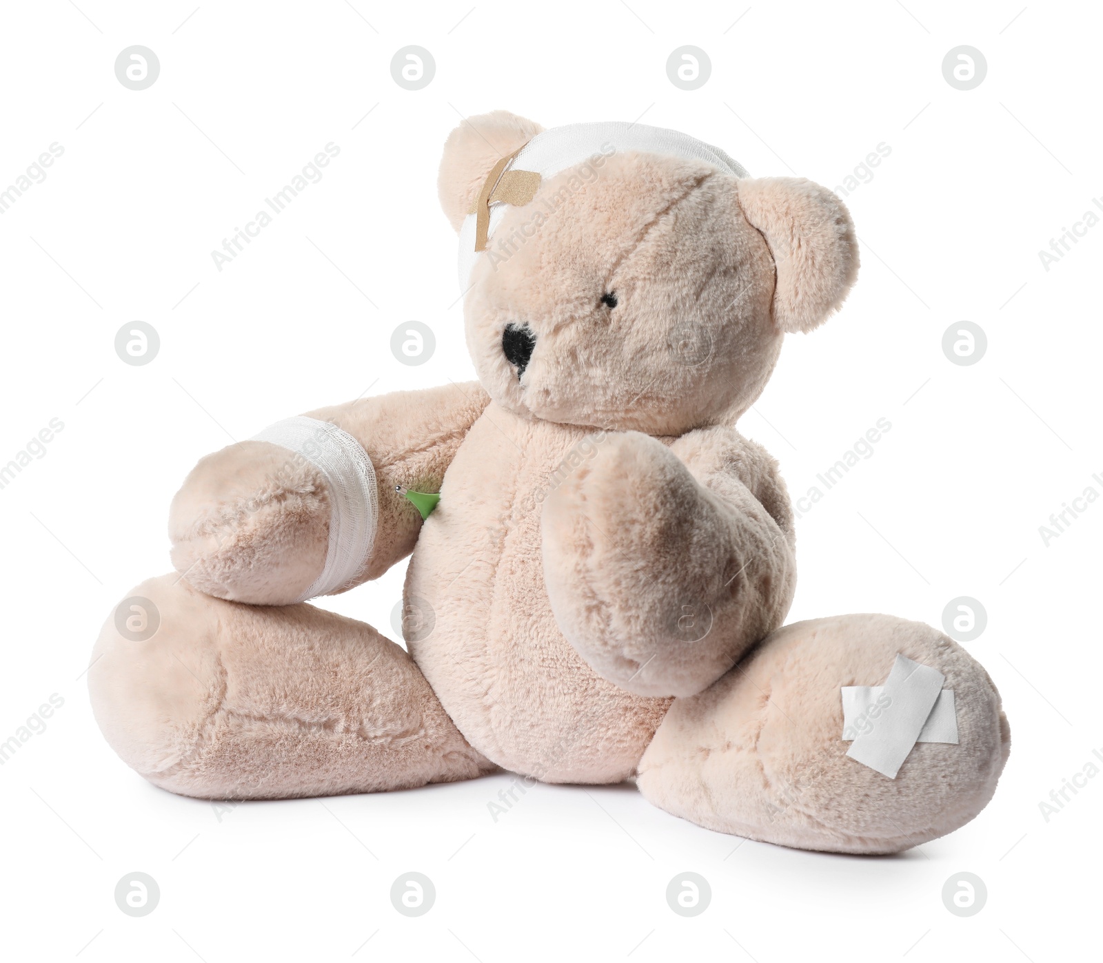 Teddy bear with bandages, adhesive medical plasters and thermometer isolated on white Photo of Teddy bear with bandages, adhesive medical plasters and thermometer isolated on white