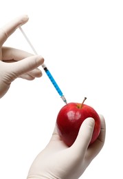 Photo of GMO concept. Scientist injecting something into fresh apple against white background, closeup