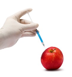 Photo of GMO concept. Scientist injecting something into fresh apple against white background, closeup