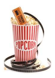 Photo of Tasty popcorn, film reel and movie ticket isolated on white