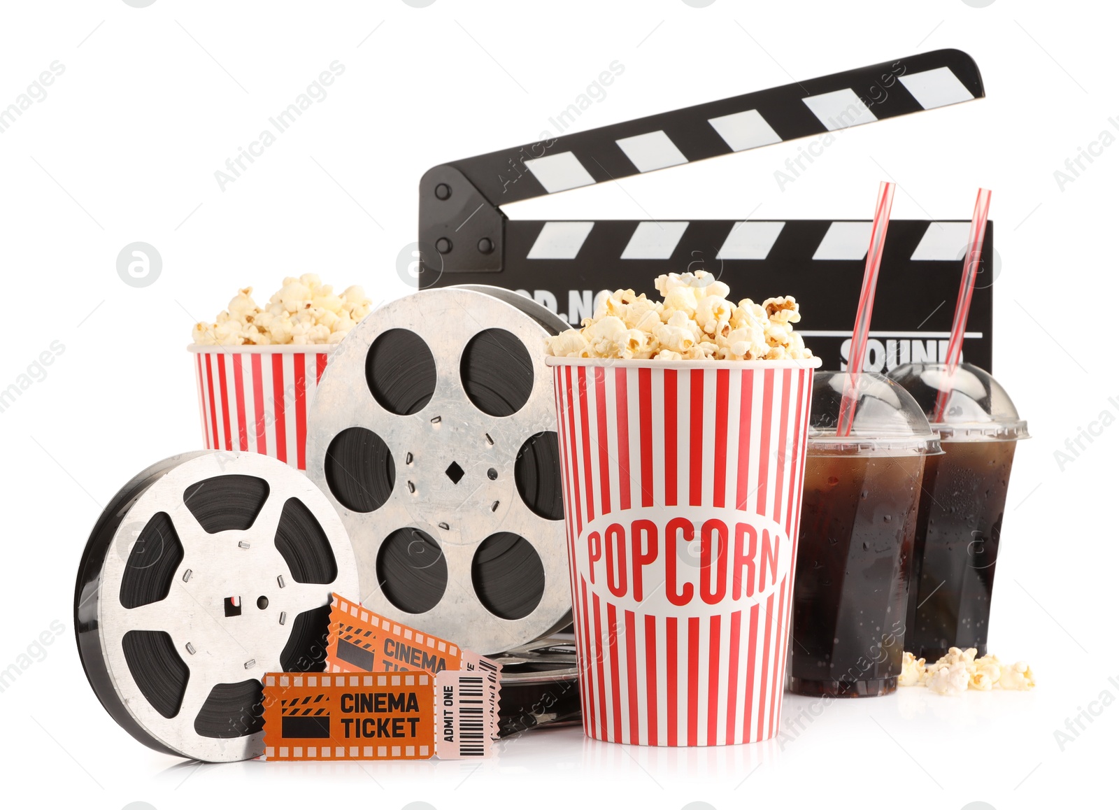 Photo of Tasty popcorn, film reels, clapper, soda drinks and movie tickets isolated on white