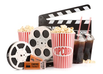 Photo of Tasty popcorn, film reels, clapper, soda drinks and movie tickets isolated on white