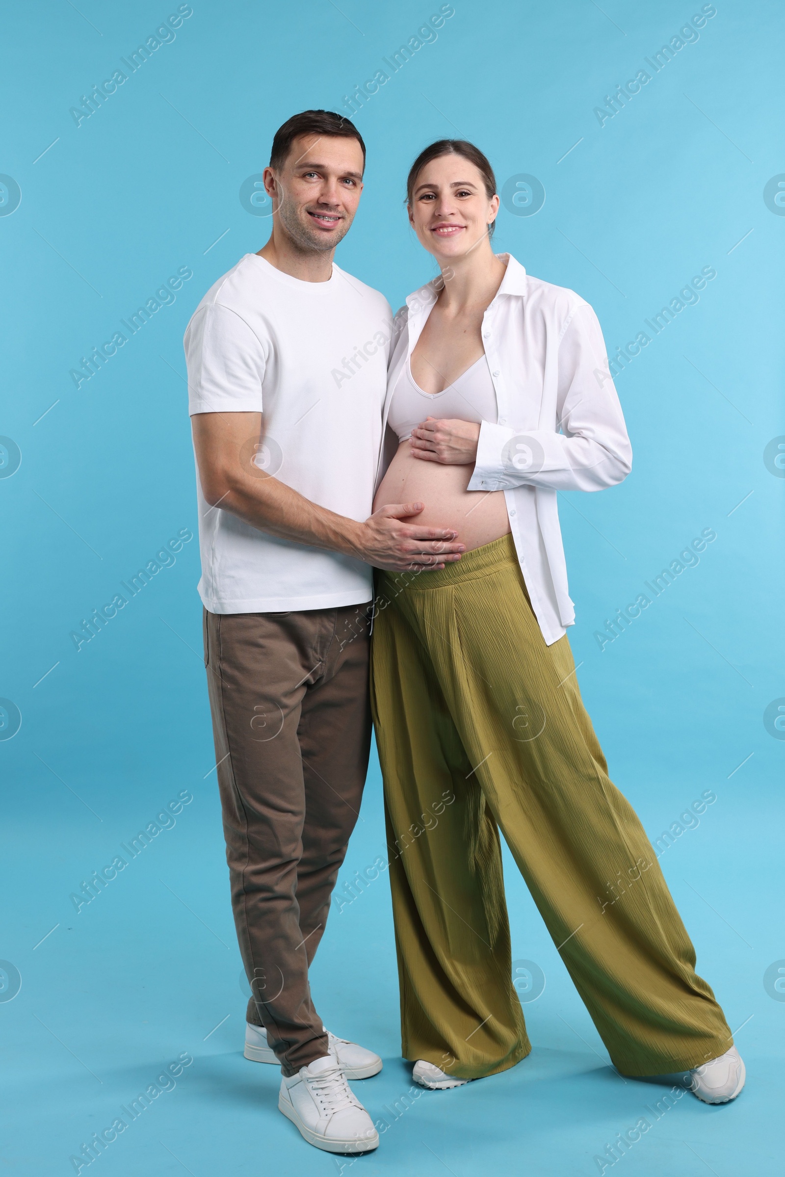 Photo of Pregnant woman and her husband on blue background