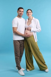 Photo of Pregnant woman and her husband on blue background