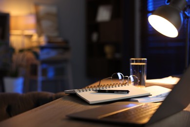 Photo of Workspace with laptop on wooden desk in home office, selective focus. Space for text