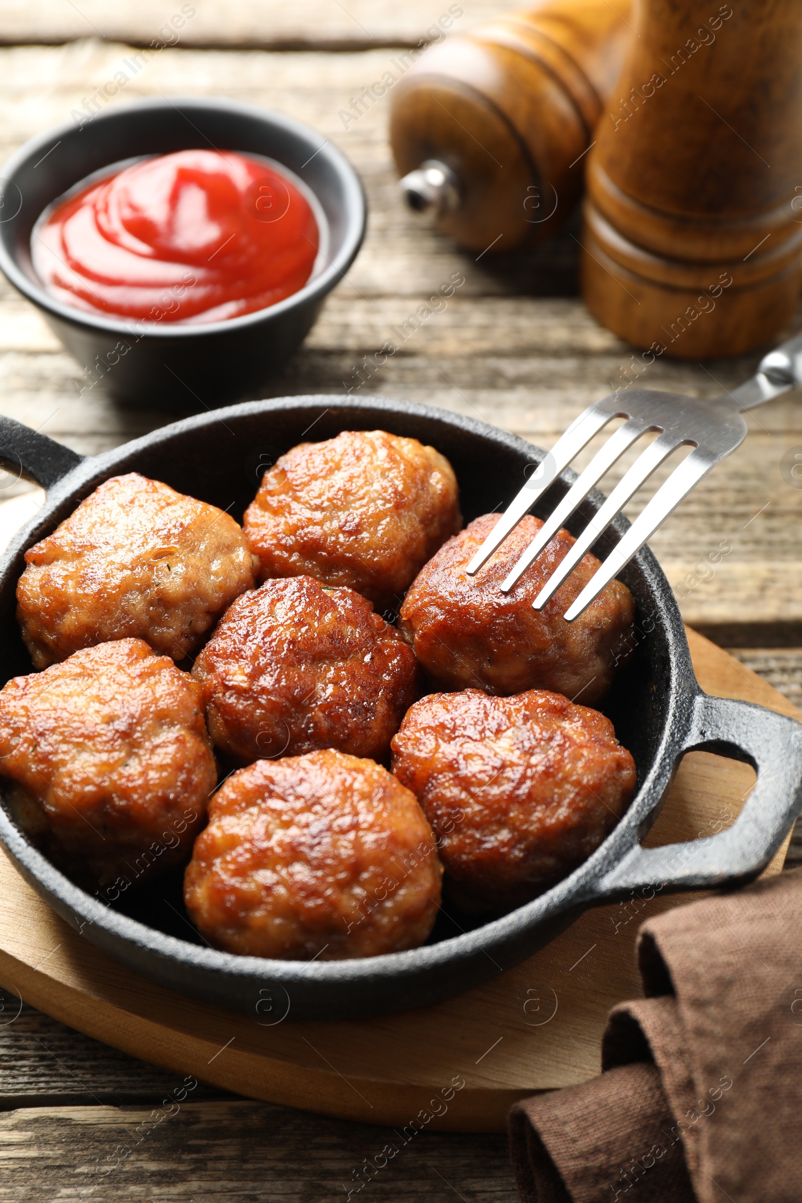 Photo of Tasty meatballs in baking dish served on wooden table, closeup