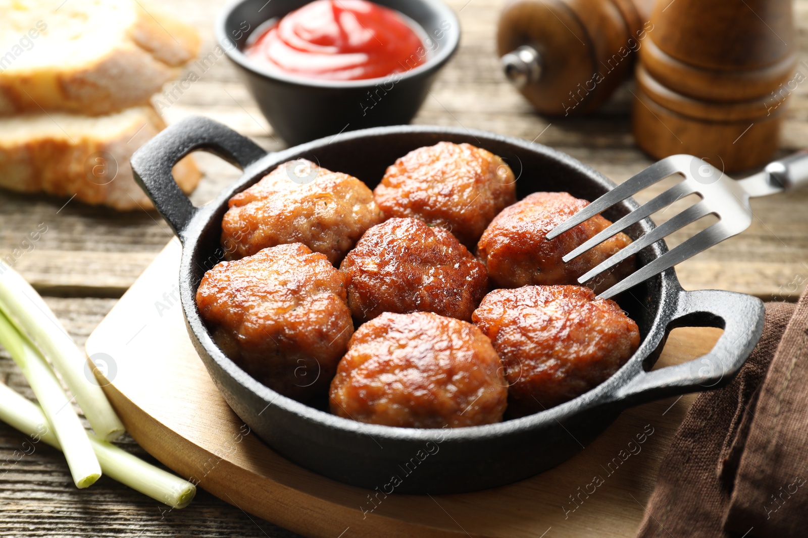 Photo of Tasty meatballs in baking dish served on wooden table, closeup