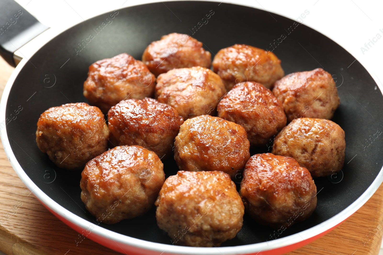 Photo of Tasty meatballs in frying pan on white table, closeup