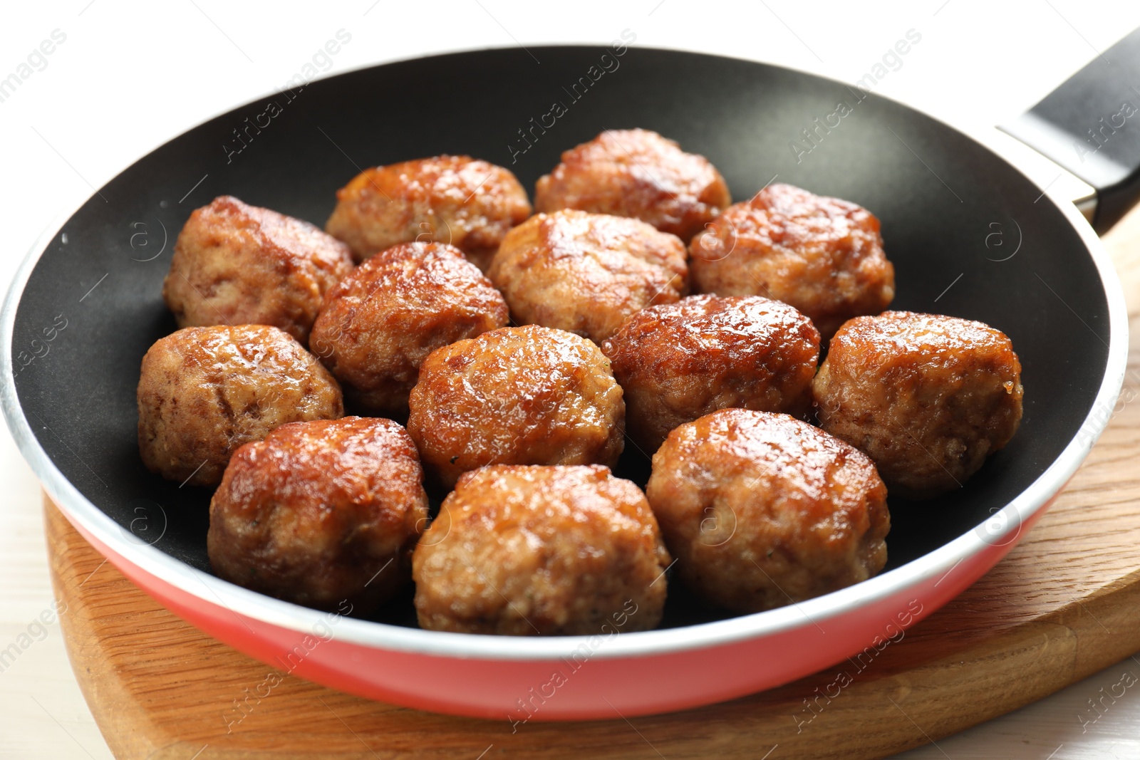 Photo of Tasty meatballs in frying pan on white table, closeup