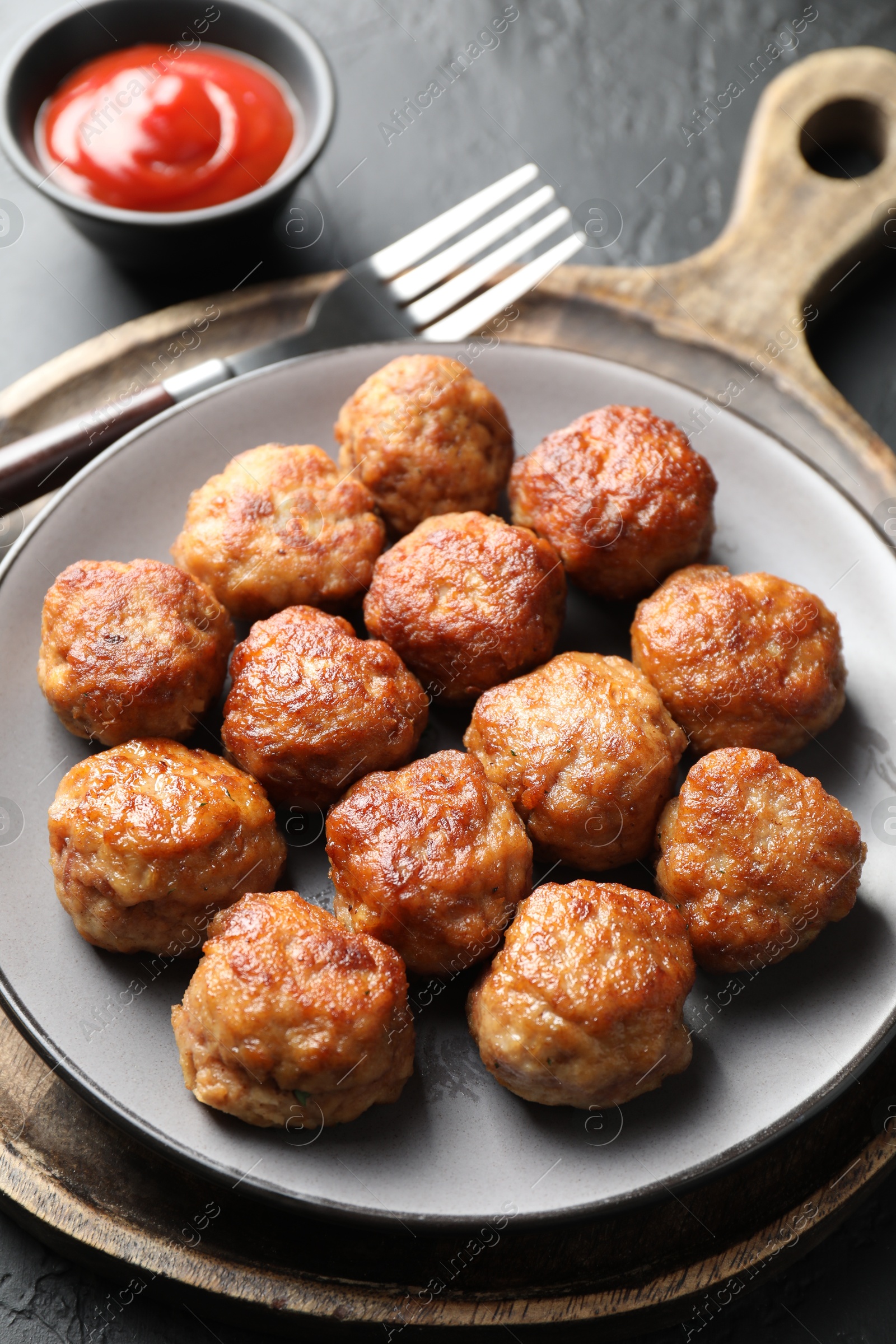 Photo of Tasty cooked meatballs served on grey table, closeup