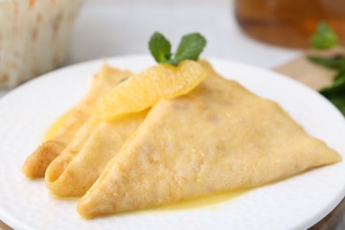 Photo of Tasty crepes Suzette on plate, closeup. French cuisine