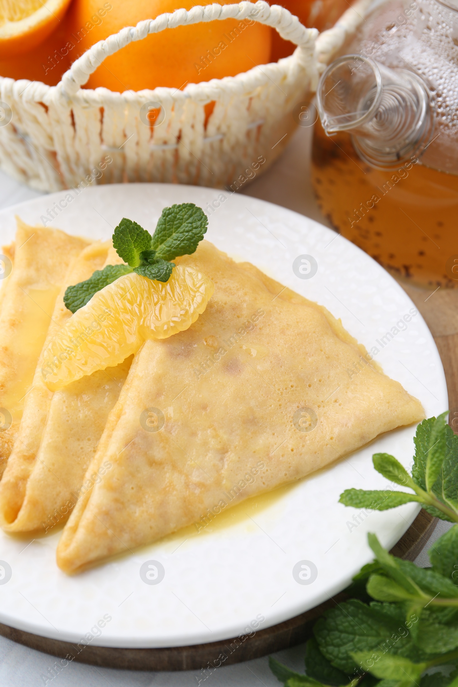 Photo of Plate with tasty crepes Suzette on table, closeup