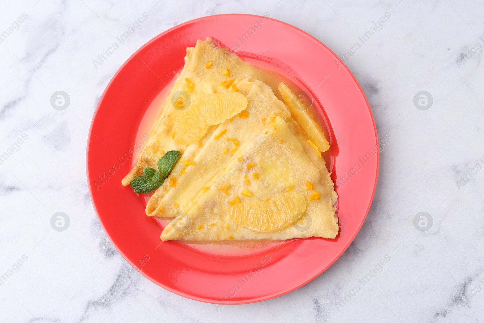 Photo of Plate with tasty crepes Suzette on white marble table, top view