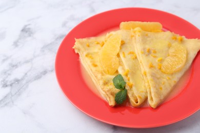 Photo of Plate with tasty crepes Suzette on white marble table, closeup. Space for text