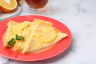 Photo of Plate with tasty crepes Suzette on white marble table, closeup. Space for text