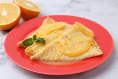 Photo of Plate with tasty crepes Suzette on white marble table, closeup