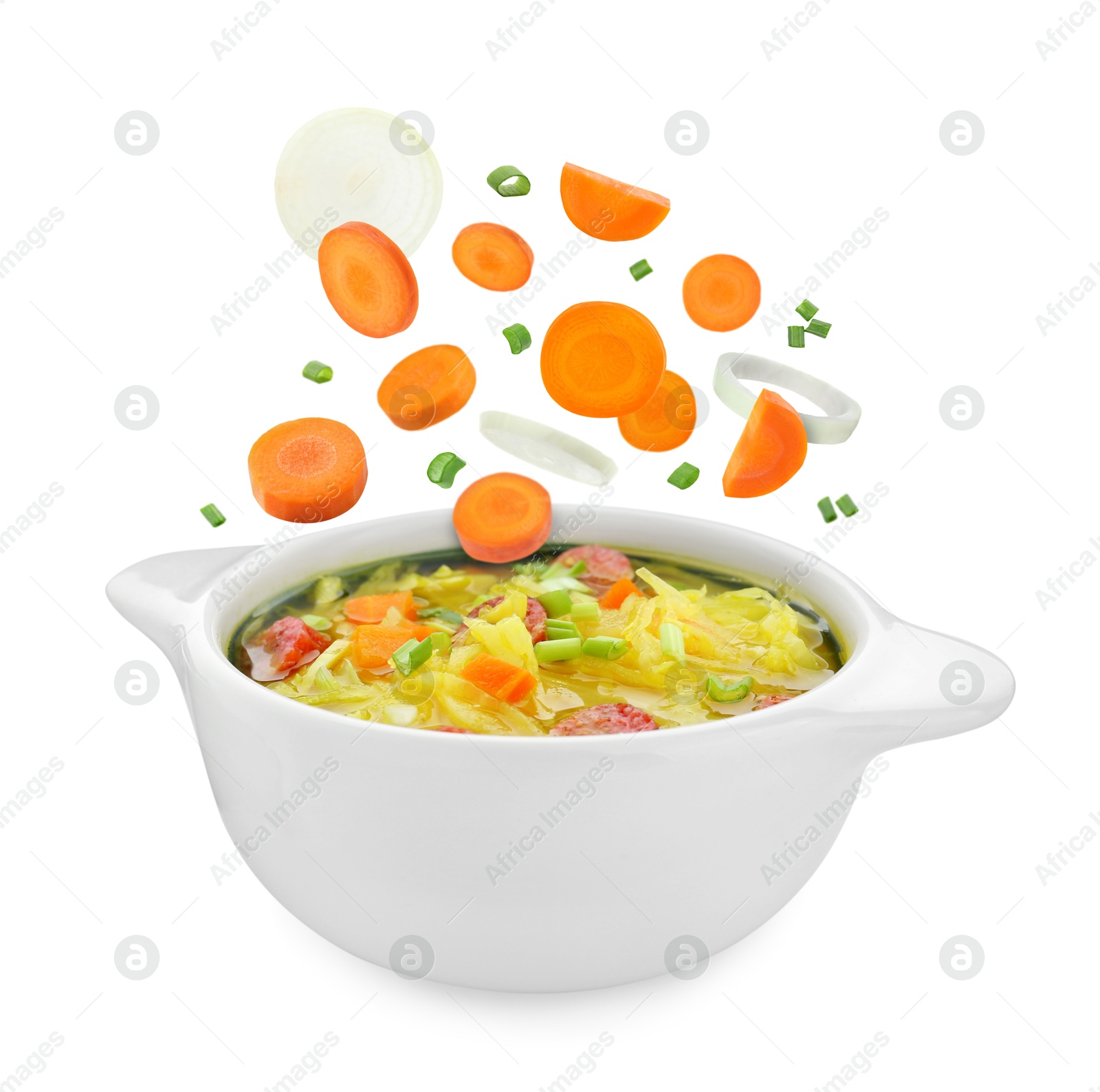 Image of Vegetables falling into pot with soup on white background