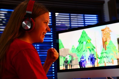 Photo of Happy girl watching game live stream indoors, low angle view