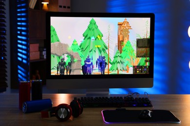 Photo of Computer keyboard, monitor, cans, headphones and mouse on table indoors