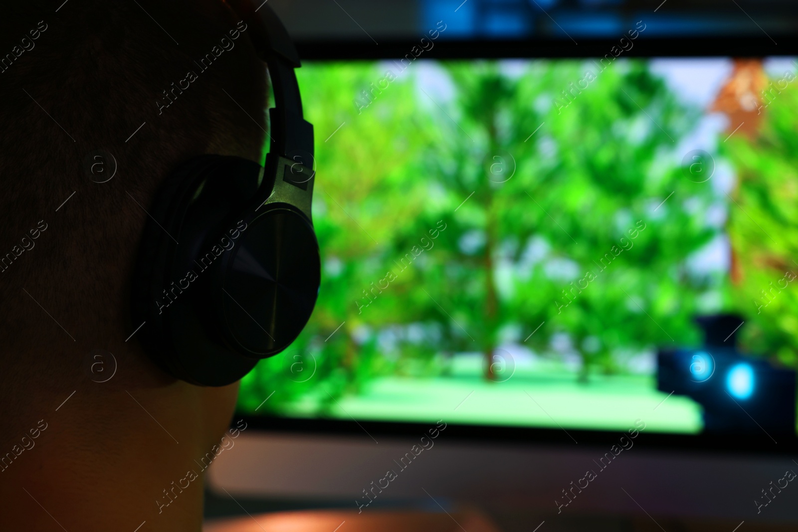 Photo of Young man playing video game at table indoors, closeup. Space for text