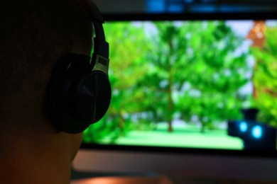 Photo of Young man playing video game at table indoors, closeup. Space for text