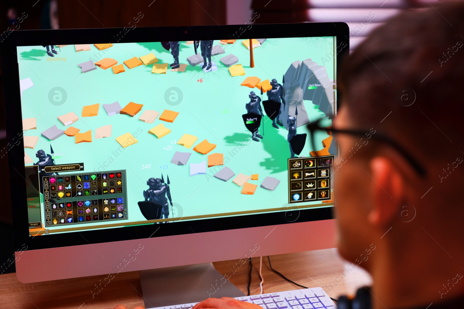 Photo of Young man playing video game at table indoors, closeup