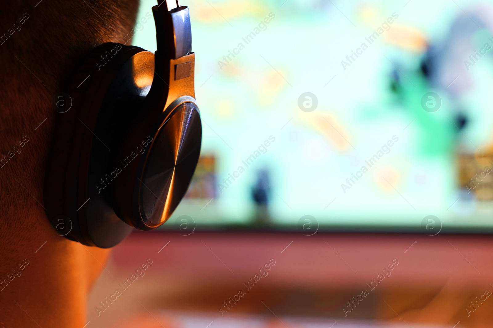 Photo of Young man playing video game at table indoors, closeup. Space for text