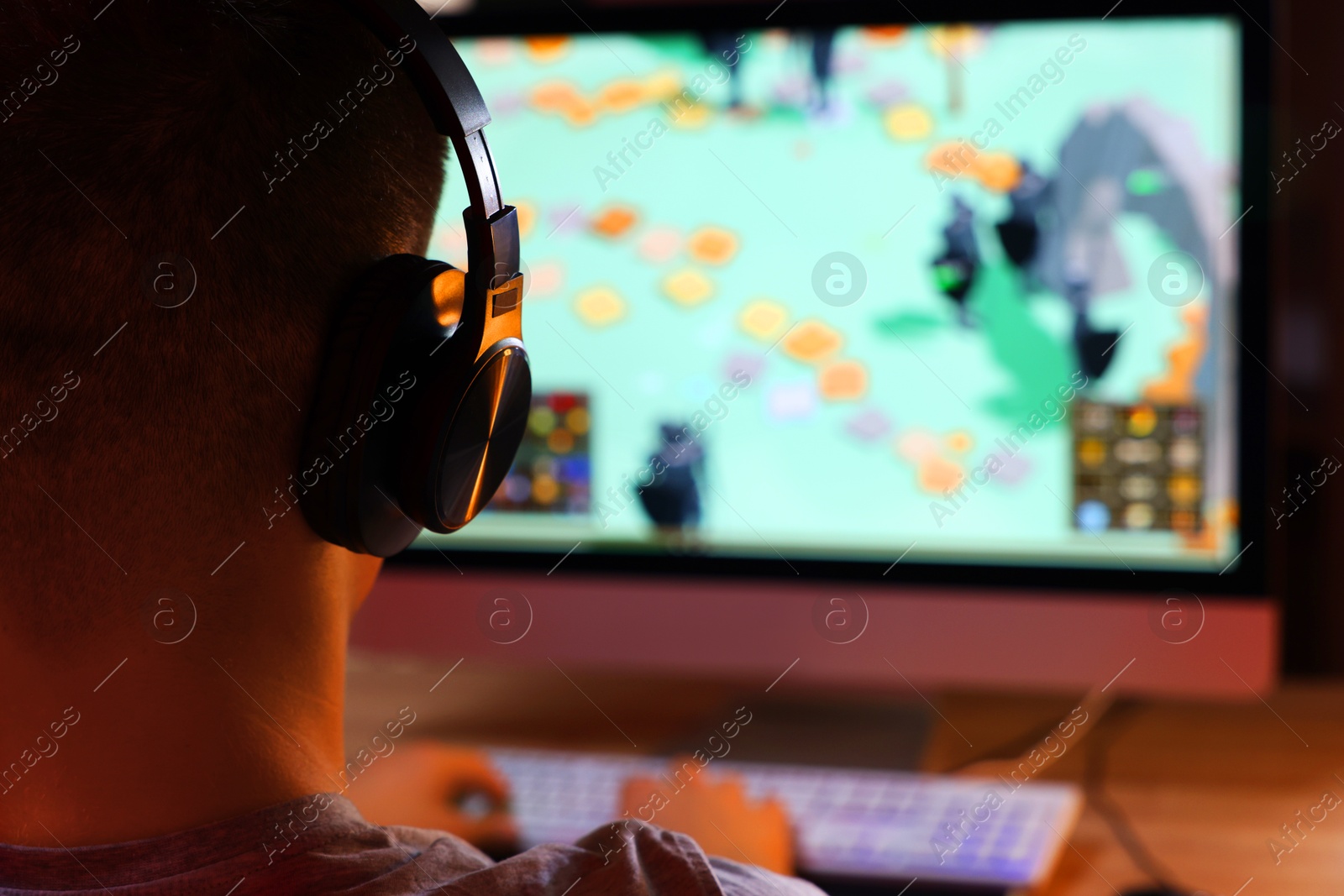 Photo of Young man playing video game at table indoors, closeup. Space for text