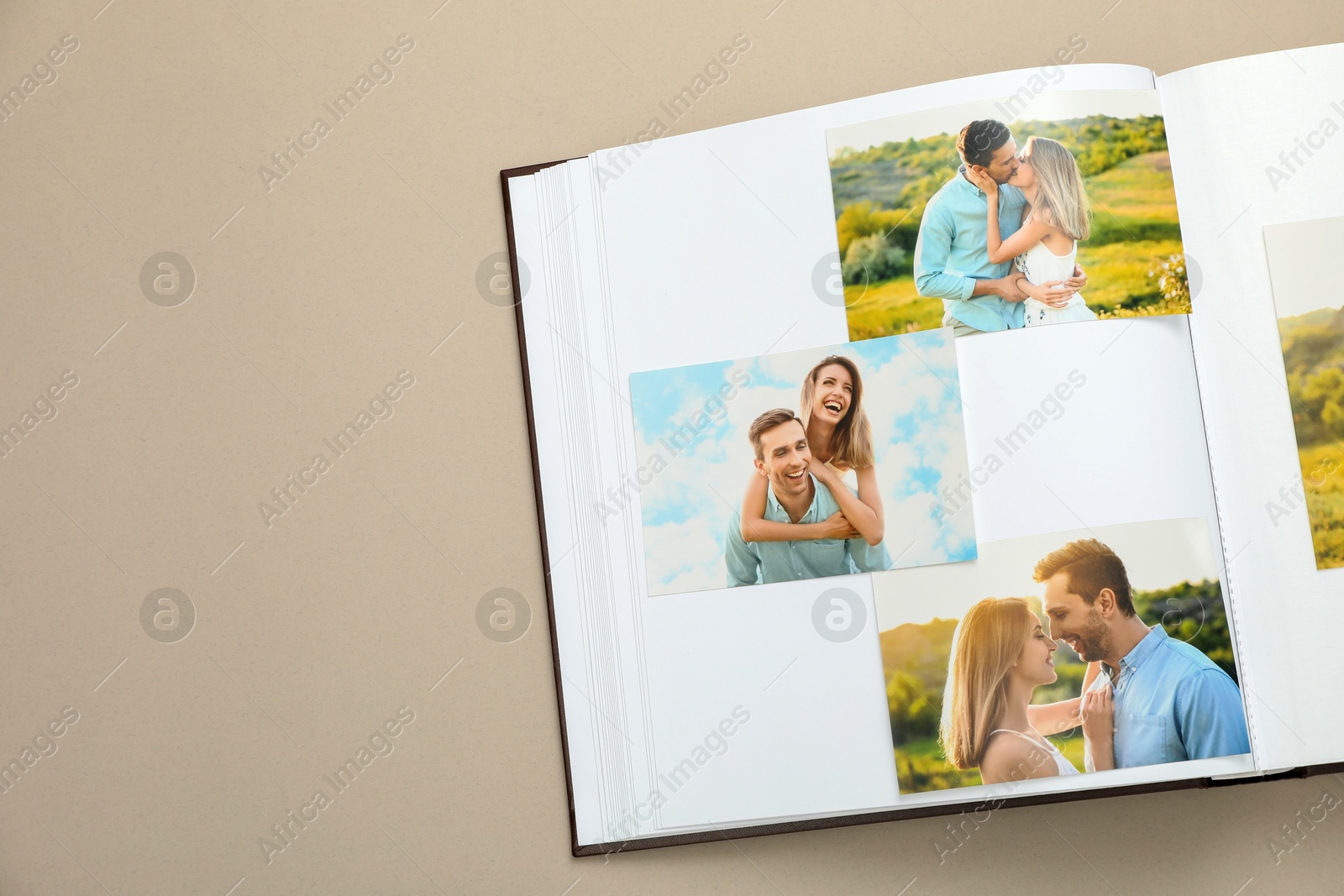 Photo of Open photo album with different photos on beige background, top view. Space for text