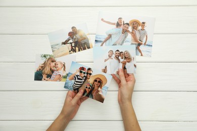 Photo of Woman with different photos at white wooden table, top view