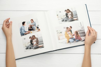 Photo of Woman with different photos in open photo album at white wooden table, top view