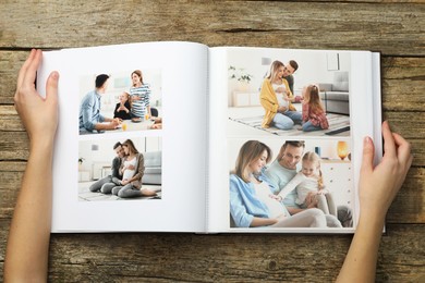 Photo of Woman with different photos in open photo album at wooden table, top view