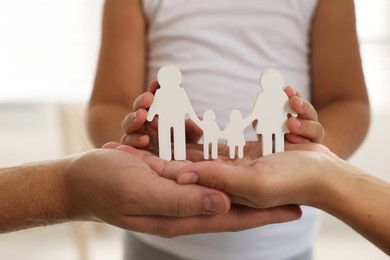 Photo of Parents and child with figures of family indoors, closeup