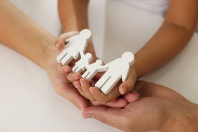 Photo of Parents and child with figures of family at white table, closeup