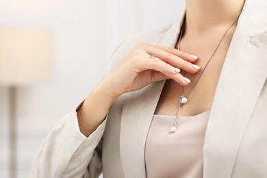 Photo of Woman wearing elegant ring and necklace indoors, closeup