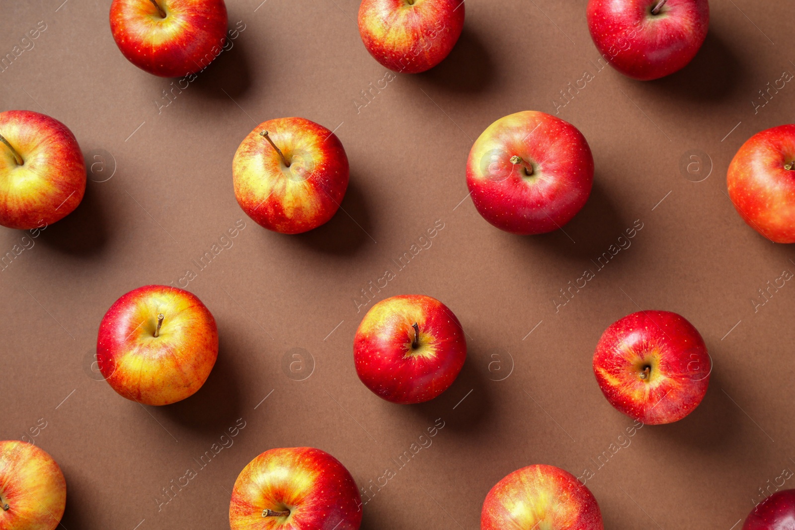 Photo of Ripe red apples on brown background, flat lay