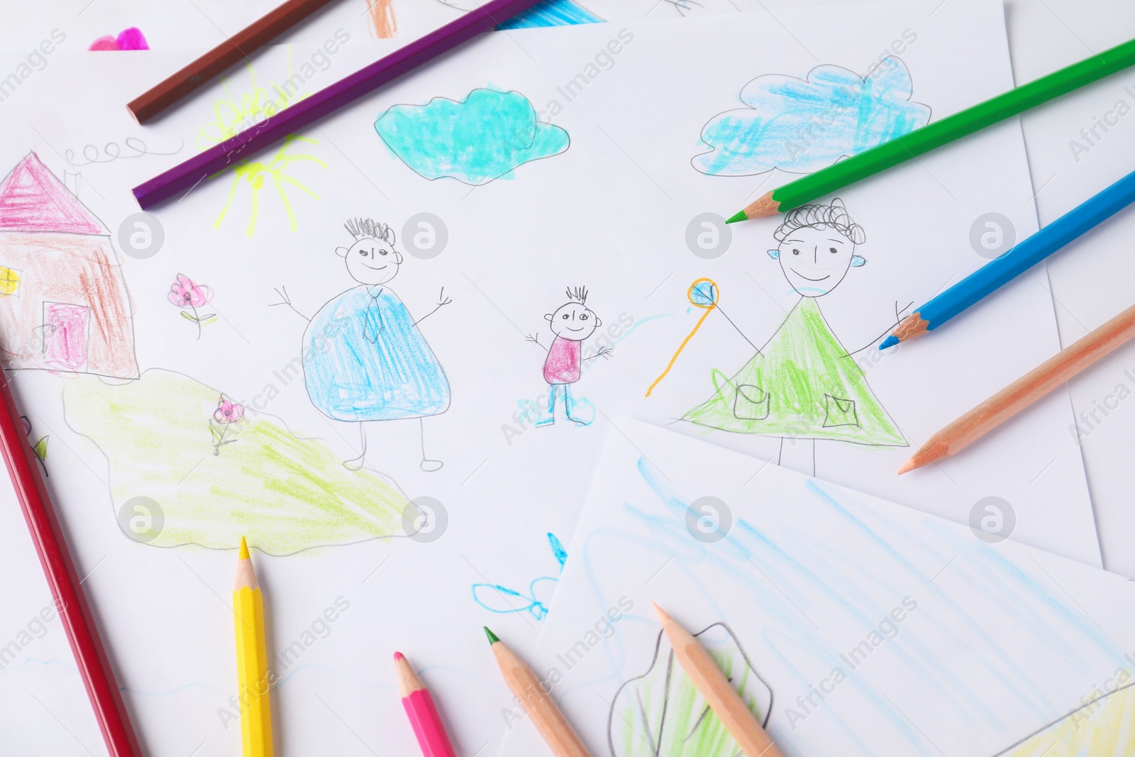 Photo of Child's drawing of happy family and pencils as background, top view