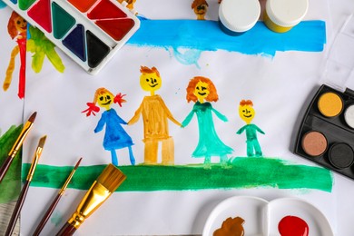 Photo of Child's drawing of happy family and supplies as background, top view