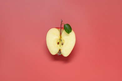 Photo of Half of fresh ripe apple on red background, top view