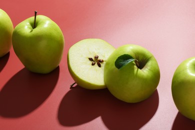 Photo of Whole and cut apples on red background, closeup