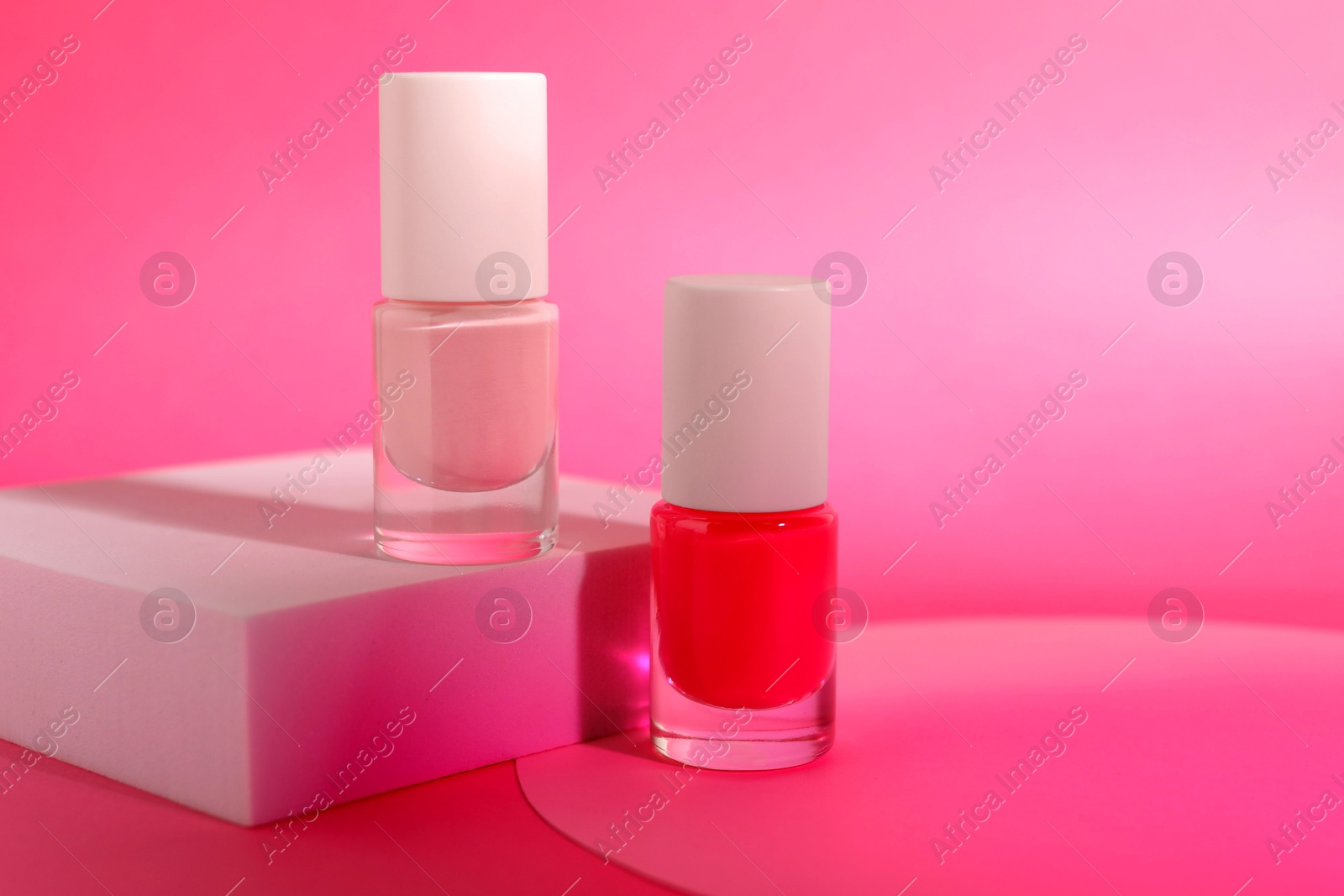 Photo of Nail polish in bottles on pink background